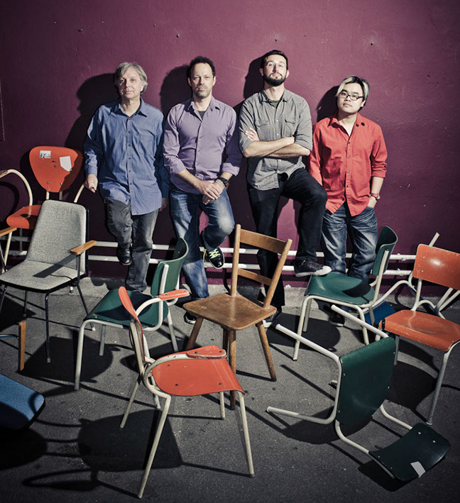 Ron Lawrence, Gregor Huebner, Jeremy Harman, and Fung Chern Hwei standing in back of empty chairs.