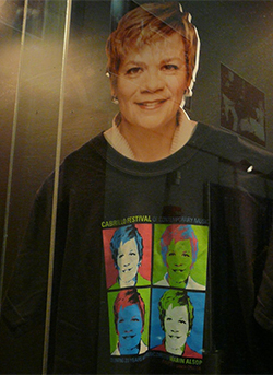 a cardboard cutout of Alsop in a display case wearing a commemorative t-shirt featuring four more Alsops a cardboard cutout of Alsop in a display case wearing a commemorative t-shirt featuring four more Alsops